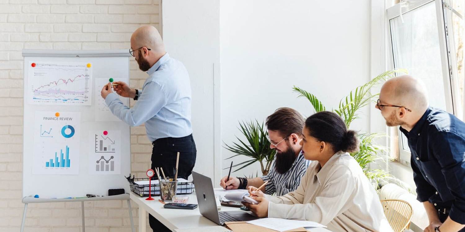Team analyzing data and discussing strategies in a bright, modern office.